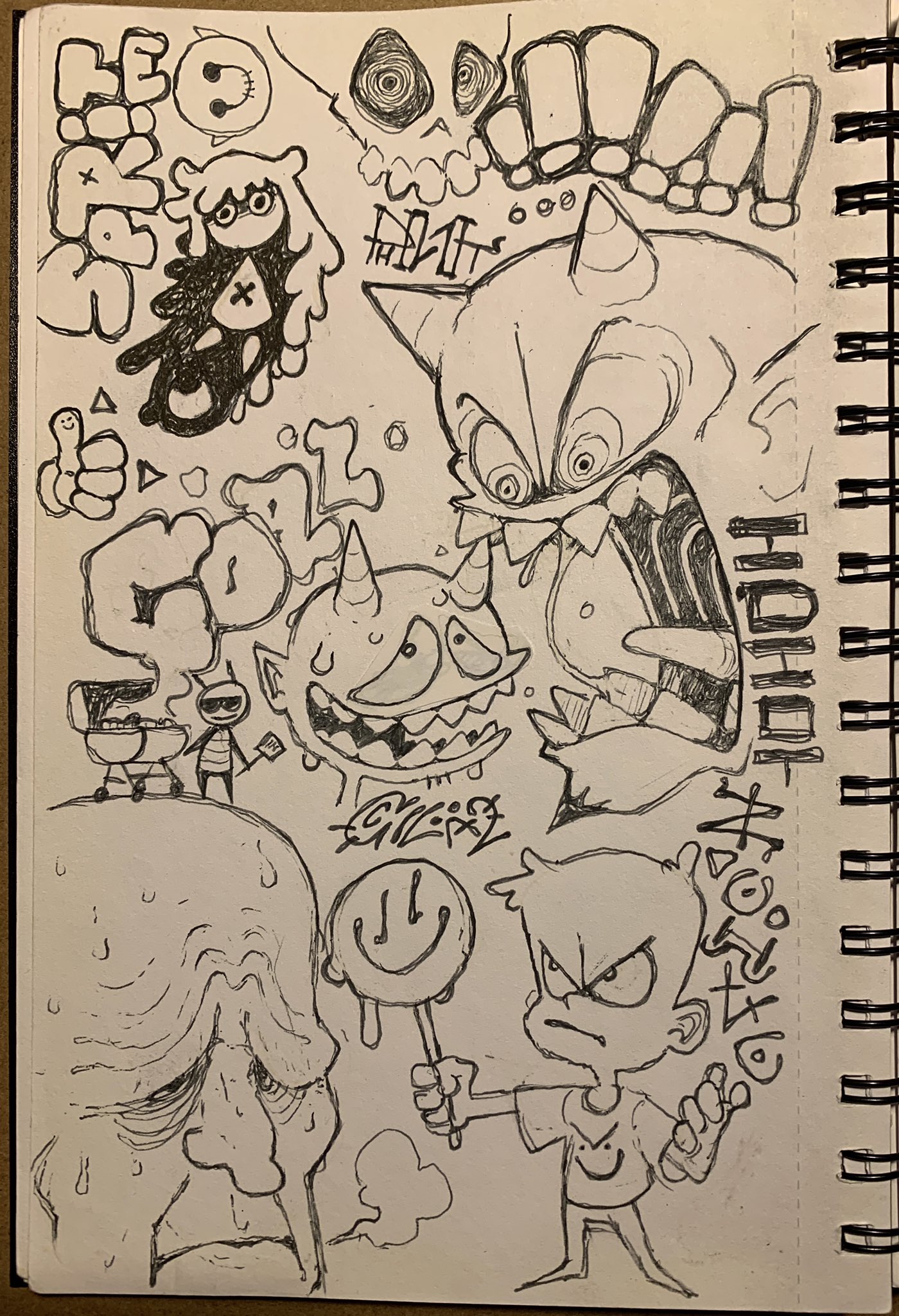 the image shows a page from a sketchbook filled with various cartoon monster doodles drawn in pencil.  the drawings depict a variety of creatures, some with horns, sharp teeth, and exaggerated features. the drawings are rendered in a loose and expressive style, with visible pencil strokes and shading.
