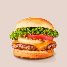 a juicy cheeseburger on a sesame seed bun with fresh lettuce, tomato, onion, and pickles.