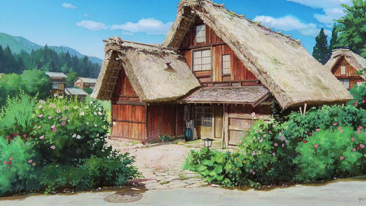 the image shows a traditional japanese house with a thatched roof. the house is made of wood and has a small porch. there is a person standing in front of the house. the house is surrounded by lush greenery and there are mountains in the background. the sky is blue and there are some clouds. the overall atmosphere of the image is peaceful and serene.