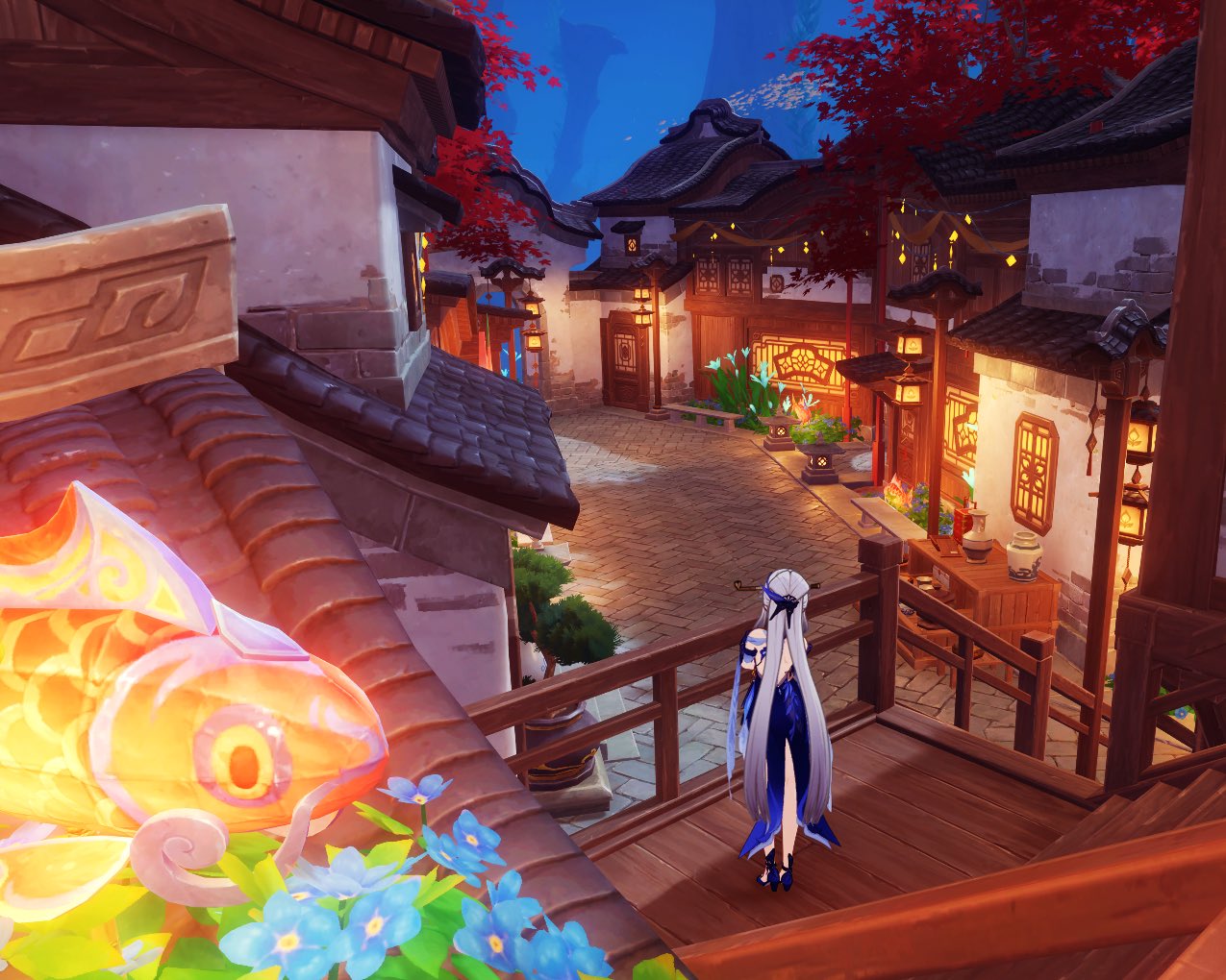 the image is a screenshot from the video game genshin impact, specifically depicting a scene in inazuma. the setting is a quaint, beautifully lit village at night, featuring traditional japanesestyle architecture with wooden houses and ornate lanterns.  a female character with long, flowing blue hair and a blue dress stands on a wooden balcony overlooking the street.  a large, glowing koi fish lantern is visible in the foreground, adding to the festive atmosphere.  forgetmenot flowers are also present, near the lantern.  the overall scene is peaceful and serene, suggestive of a lantern festival or a similar nighttime celebration.