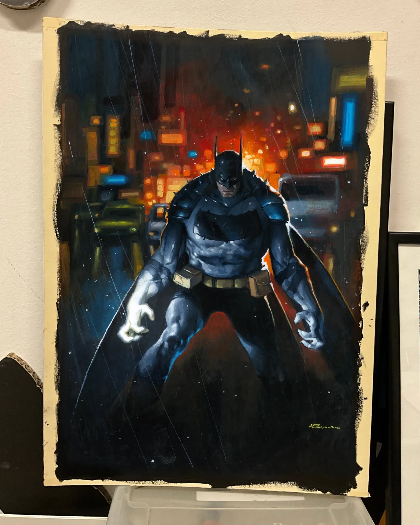 a painting of batman in a city at night. it is raining, and the city lights are blurred. batman is standing in the middle of the street, looking menacing. the painting is signed by r. bonanno.