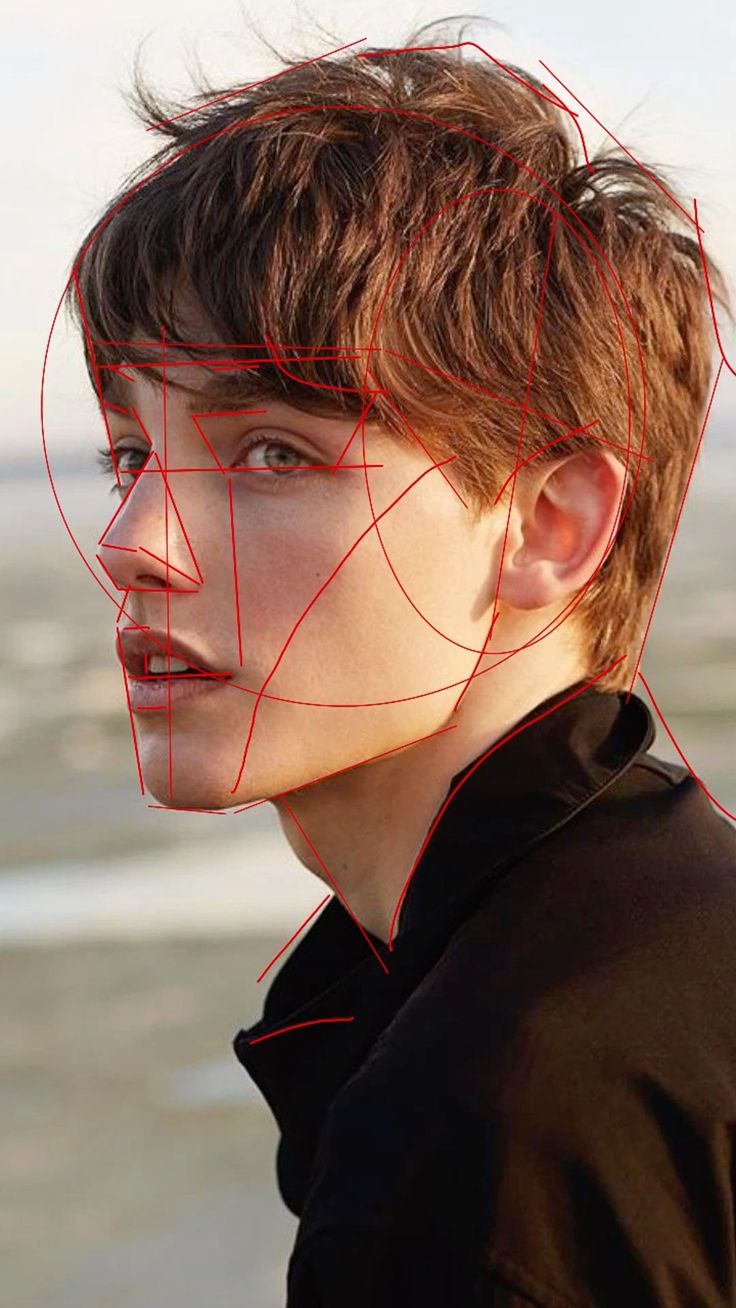 closeup profile shot of a young man with short, brown hair.  he's wearing a darkcolored jacket. the background is blurred, suggesting an outdoor setting near a body of water. a red geometric overlay is present on the image, seemingly outlining the underlying structure of his face. the overall mood is stylish and somewhat artistic.
