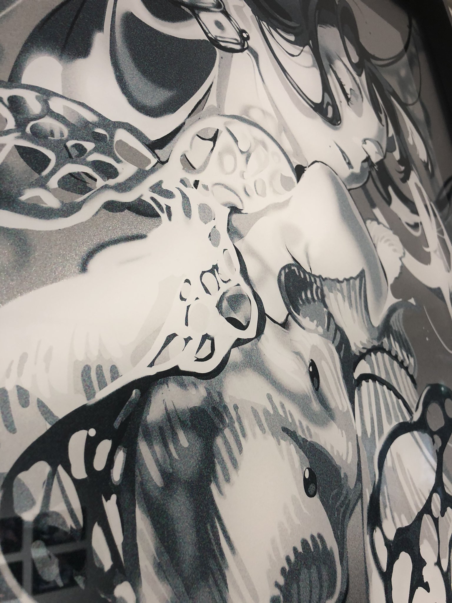the image showcases a closeup view of an abstract, black and white painting. the artwork features skeletal and anatomical forms, reminiscent of skulls and bones, intertwined in a visually dynamic composition. the monochrome palette enhances the contrast and highlights the intricate details of the artwork.