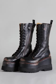 a pair of black leather platform boots with laceup detailing. the boots have a chunky platform sole and a slightly distressed look, giving them a grungeinspired aesthetic. they are a stylish and edgy choice for adding a touch of attitude to any outfit.