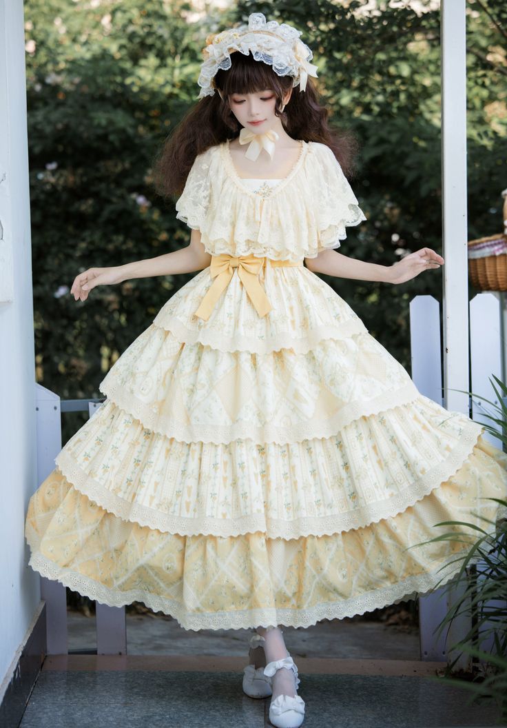 a woman wearing a long, flowing yellow dress stands outdoors on a porch. the dress has multiple layers and is decorated with lace and floral patterns. she is also wearing a matching hat and white shoes. the environment appears to be a garden or a house with a porch. the lighting is natural and soft, creating a dreamy and romantic atmosphere.  the overall aesthetic of the image is inspired by vintage and cottagecore styles.