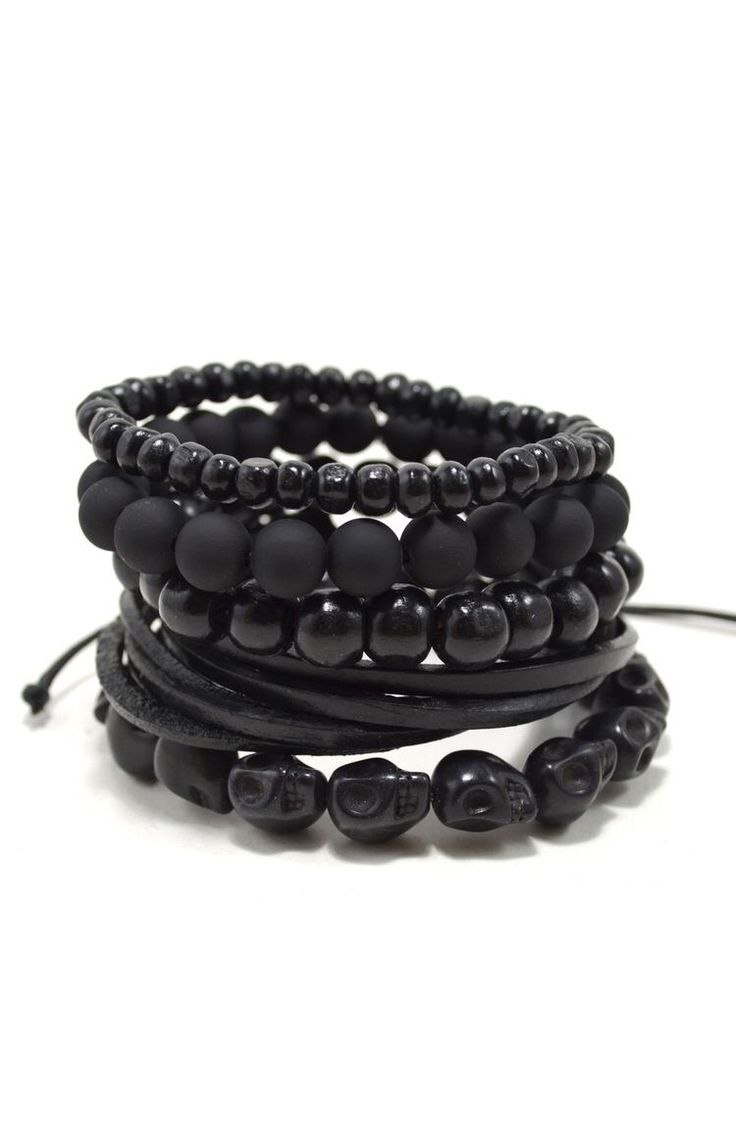 a black beaded bracelet with skulls on it. it is stackable and has a leather strap.  it appears to be a men's bracelet.