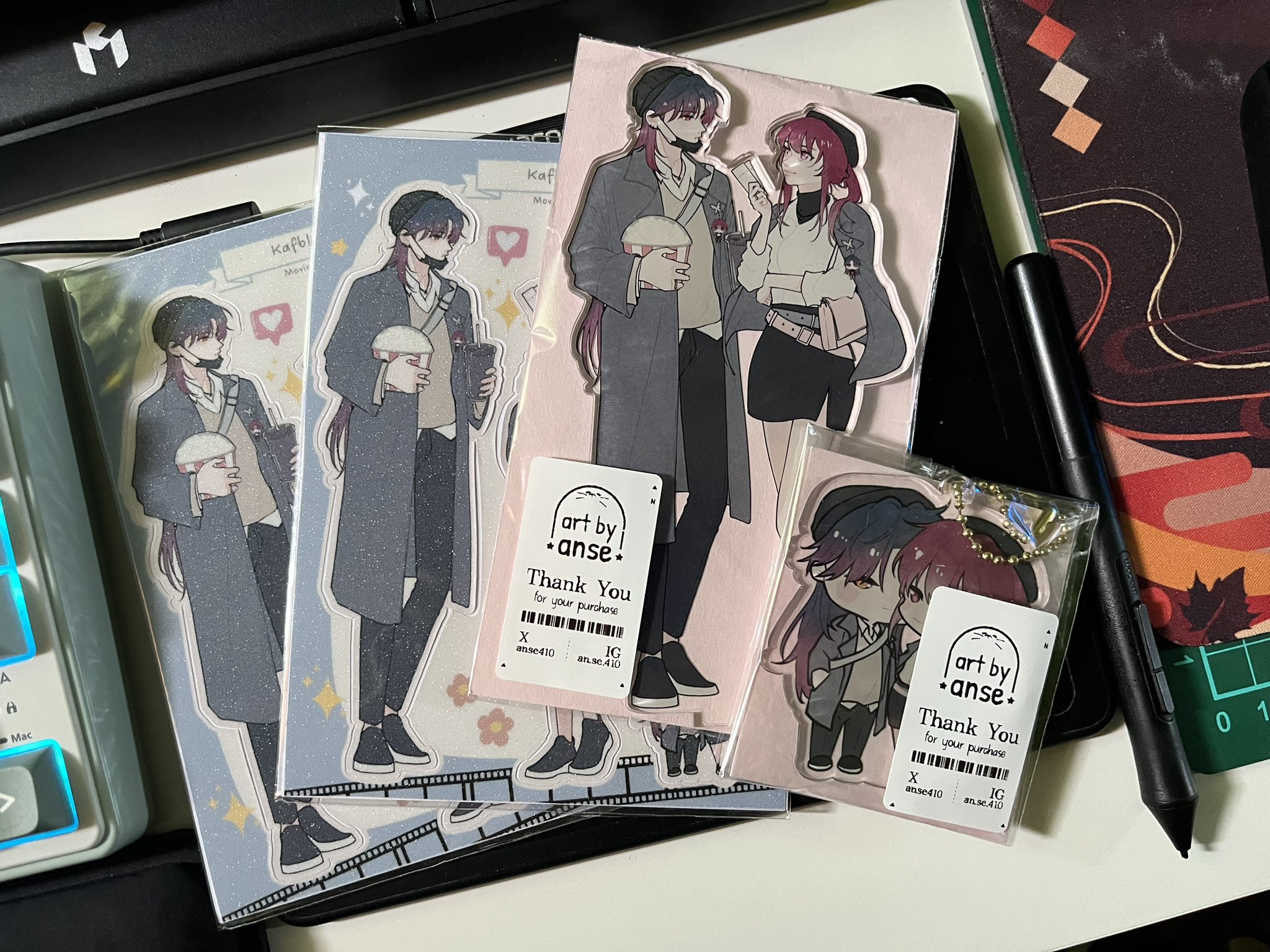 this image shows a collection of anime character cards and a keychain. the cards feature different characters from the anime, and the keychain is a chibi version of one of the characters. the cards and keychain are all beautifully drawn and designed.