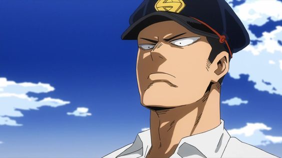 the image shows captain celebrity, a character from the anime series my hero academia. he is a tall, muscular man with short black hair and brown eyes. he is wearing his signature white and navy blue superhero costume with a red "c" on his chest. the background of the image is a bright blue sky with some white clouds. the image is a closeup of captain celebrity's face, and he has a serious expression on his face.