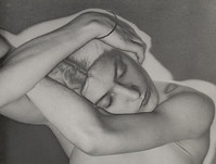 a black and white closeup photograph of a woman reclining, her arms curled around her head. she appears to be sleeping or resting, her eyes closed and her expression serene. the image is softfocus and has a timeless quality. the woman's body is partially visible, and the composition is intimate and sensual. the photograph's style is artistic and evocative.