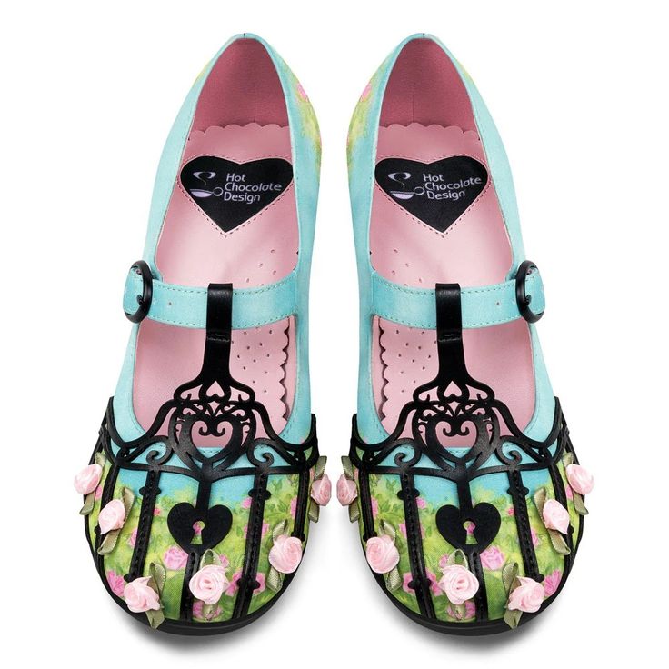 a pair of hot chocolate design mary jane shoes. they are blue and pink with floral decorations, heartshaped design on the insole, and heartshaped keyhole design on the toe.
