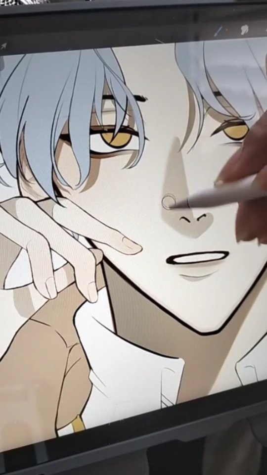 the image shows a closeup view of a digital drawing in progress on a tablet screen. the artwork depicts a young animestyle male character with grey hair, yellow eyes, and what appears to be a nose piercing. the character's hand is near their face, creating a pensive or selfaware pose. a hand holding a stylus is partially visible in the upper right corner, indicating the artist is adding details to the drawing, likely using a digital drawing program.  the style of the art is clean and stylized, typical of anime or manga character design. the drawing is at a stage where line art and basic shading have been applied, but finer details and coloring are still to be completed. the overall tone is serene and expressive.