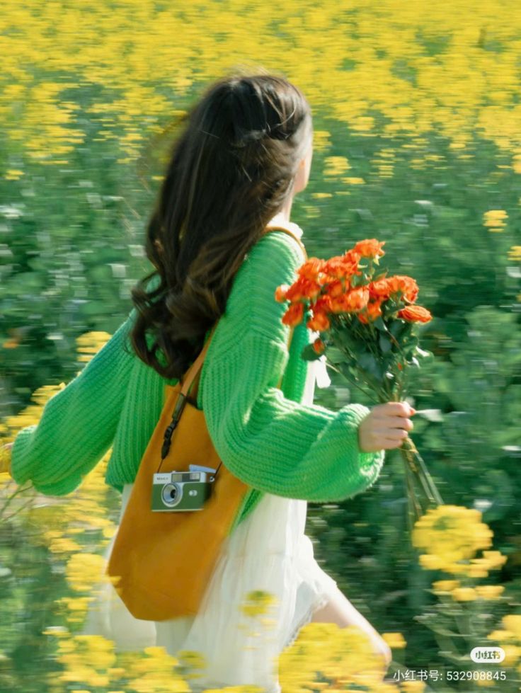 the image depicts a young woman with long brown hair running through a vibrant field of yellow rapeseed flowers. she is wearing a bright green knitted sweater and a white skirt, carrying a mustardyellow tote bag with a vintagestyle camera inside and a bouquet of orange roses.  the photo has a motion blur effect, emphasizing the feeling of movement and energy. the overall mood is bright, cheerful, and idyllic, suggesting a feeling of freedom and happiness in nature. the colors are very saturated and vibrant.