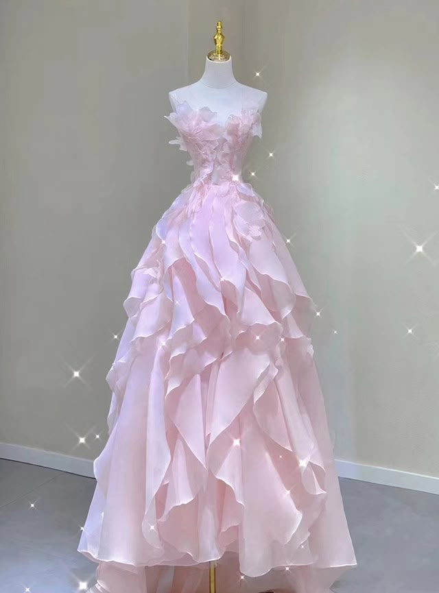 a pink, strapless gown with ruffled detailing, displayed on a mannequin. the dress appears to be formal wear, possibly a prom or wedding dress.