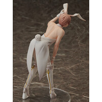 back view of an anime figurine of a bunny girl. the figure is wearing a white dress and bunny ears.  the figurine is posed with one hand on her hip and the other near her waist. the background is a mottled greybrown surface. the figure appears to be made of pvc or similar material. the details are sharp and the pose is dynamic.
