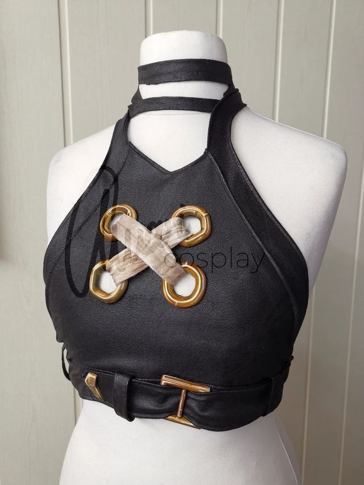a black leather halter top with a gold buckle and belt. the top is a crop top, and it has grommets around the neckline. the top is worn on a white mannequin. it is a cosplay costume.