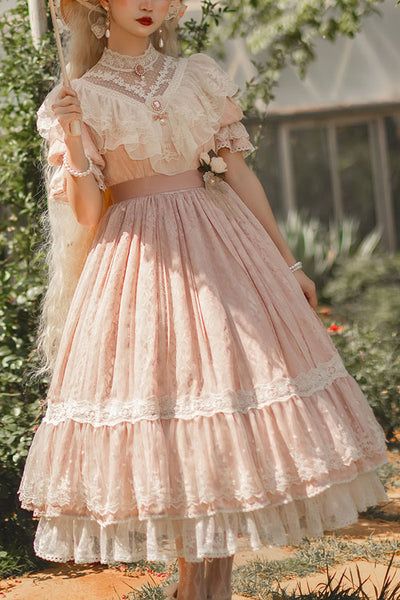 a woman in a vintageinspired pink dress stands in a garden. she holds a parasol in one hand. the dress is made of lace and tulle, and it has a full skirt. the woman is looking to the side, and she has a serene expression on her face. the garden is lush and green, and the sun is shining.