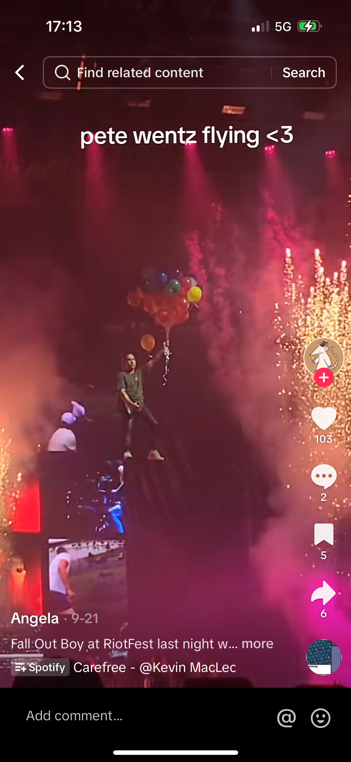 this is a photo of pete wentz from the band fall out boy performing at riotfest. the image is taken from a mobile device, capturing the performance on stage. the crowd is visible, and the lights and balloons create a vibrant and festive atmosphere.