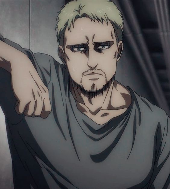 this is an animestyle drawing of reiner braun, a character from the anime and manga series attack on titan. he is shown from the chest up, leaning against a wall with his right arm extended. he has a serious and stoic expression on his face.  he has short blond hair and stubble on his face. he is wearing a dark gray shirt. the background is a dark gray wall. the lighting is artificial and creates a dramatic atmosphere.