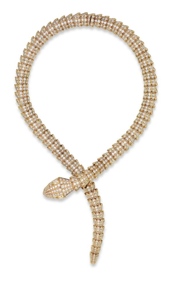 an image of a gold snake necklace encrusted with diamonds. the snake is coiled into a sort of circular design.