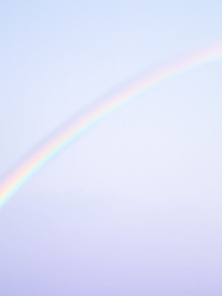 a soft, pastel rainbow arcs across a pale lavender sky. the colors of the rainbow are subtle and dreamy, blending seamlessly into the delicate hues of the clouds. the image evokes a sense of tranquility and wonder, as if a magical moment has been captured in time.