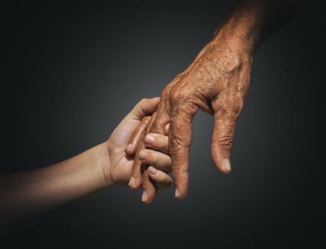 an elderly hand holding a young hand, showing a strong bond between generations. the image is about love, care, and support.