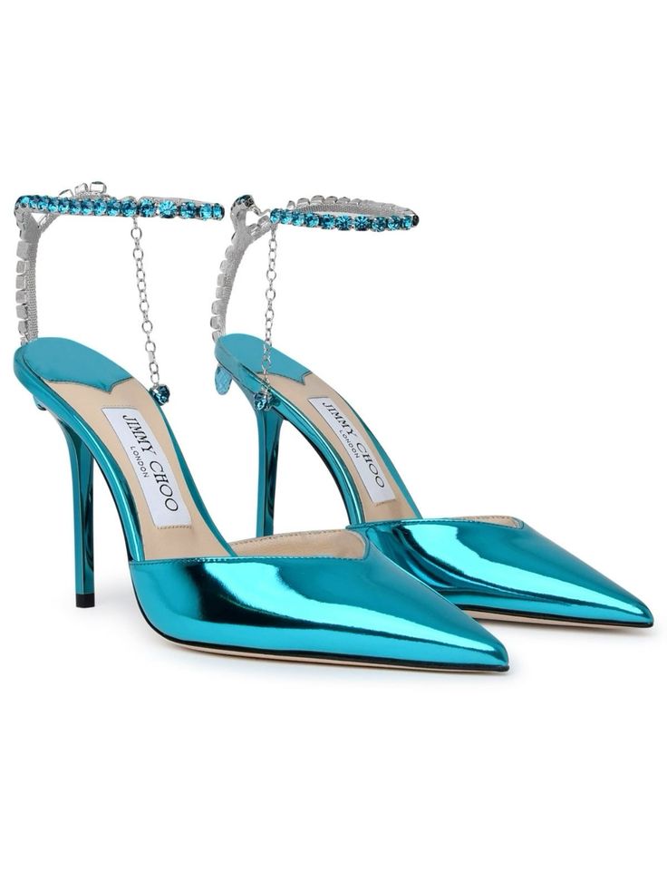 a pair of jimmy choo turquoise metallic pointedtoe heels with crystalembellished ankle straps are shown in the image. the shoes are positioned at a slight angle, with one shoe slightly in front of the other. the shoes are beautifully detailed, highlighting the brand's luxury and craftsmanship. the vibrant turquoise color and sparkling crystals add a touch of glamour and elegance.