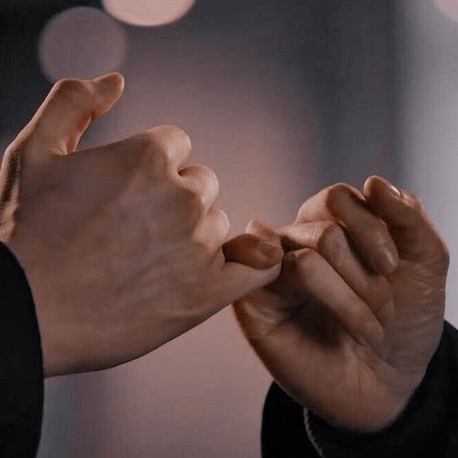 a closeup image of two hands intertwined, with their pinky fingers interlocked in a gesture of affection and promise. the soft, warm lighting and the focus on the hands create a romantic and intimate atmosphere.