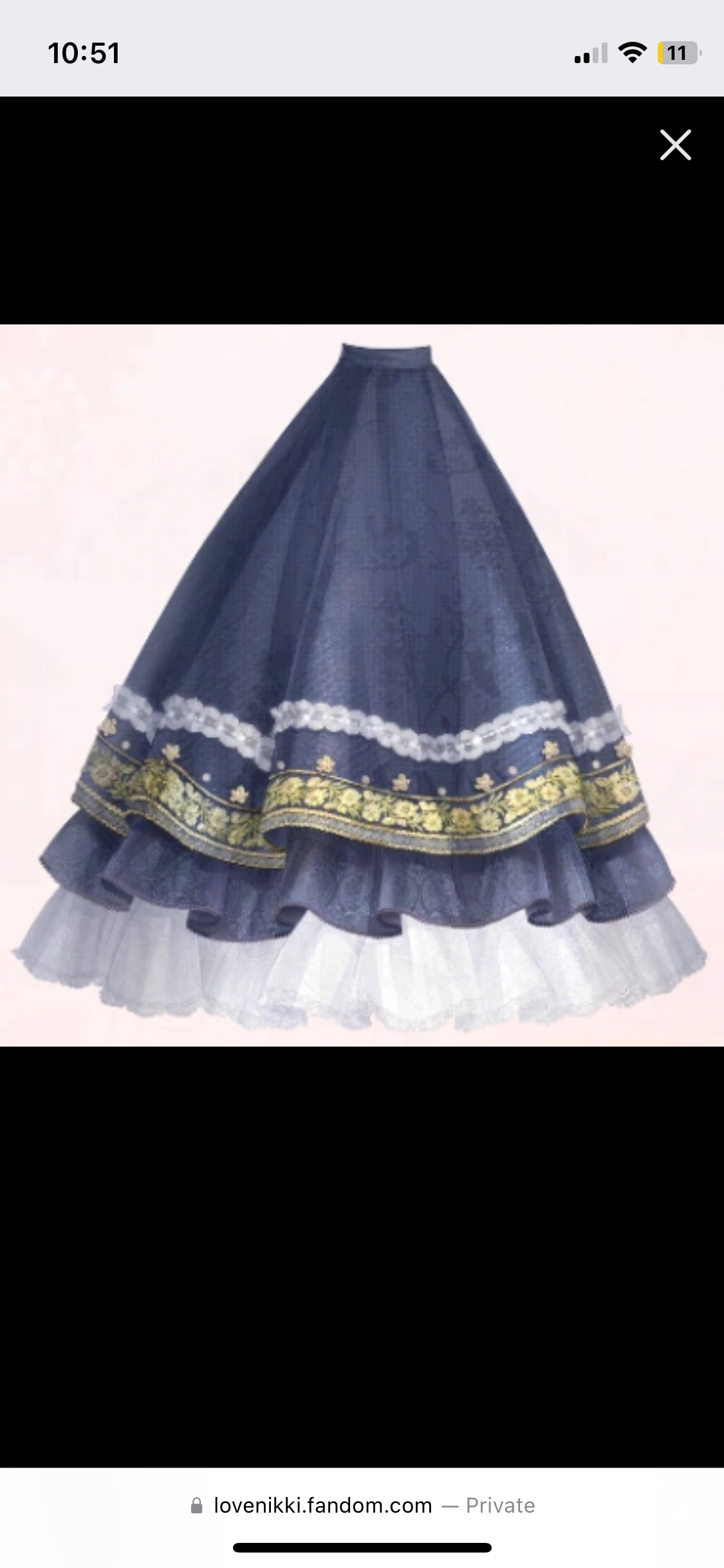 the image shows a long blue skirt with white lace and ruffles. the skirt has a floral embroidery around the waist.