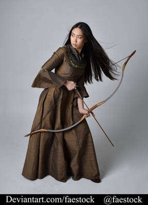 a fullbody studio shot of a young woman dressed in a medievalstyle brown gown, holding a longbow. she has long dark hair and is posing dramatically, suggesting she is an archer. the background is a plain grey. the image is from the stock photography site deviantart, by faestock.