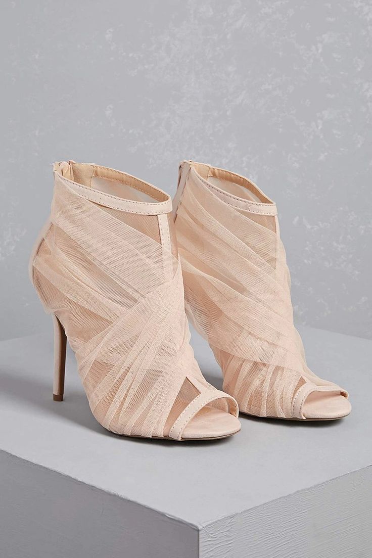 a pair of nude peeptoe heels with mesh tulle accents, a stiletto heel, and a delicate ankle strap. the shoes have a classic design and are perfect for a special occasion.
