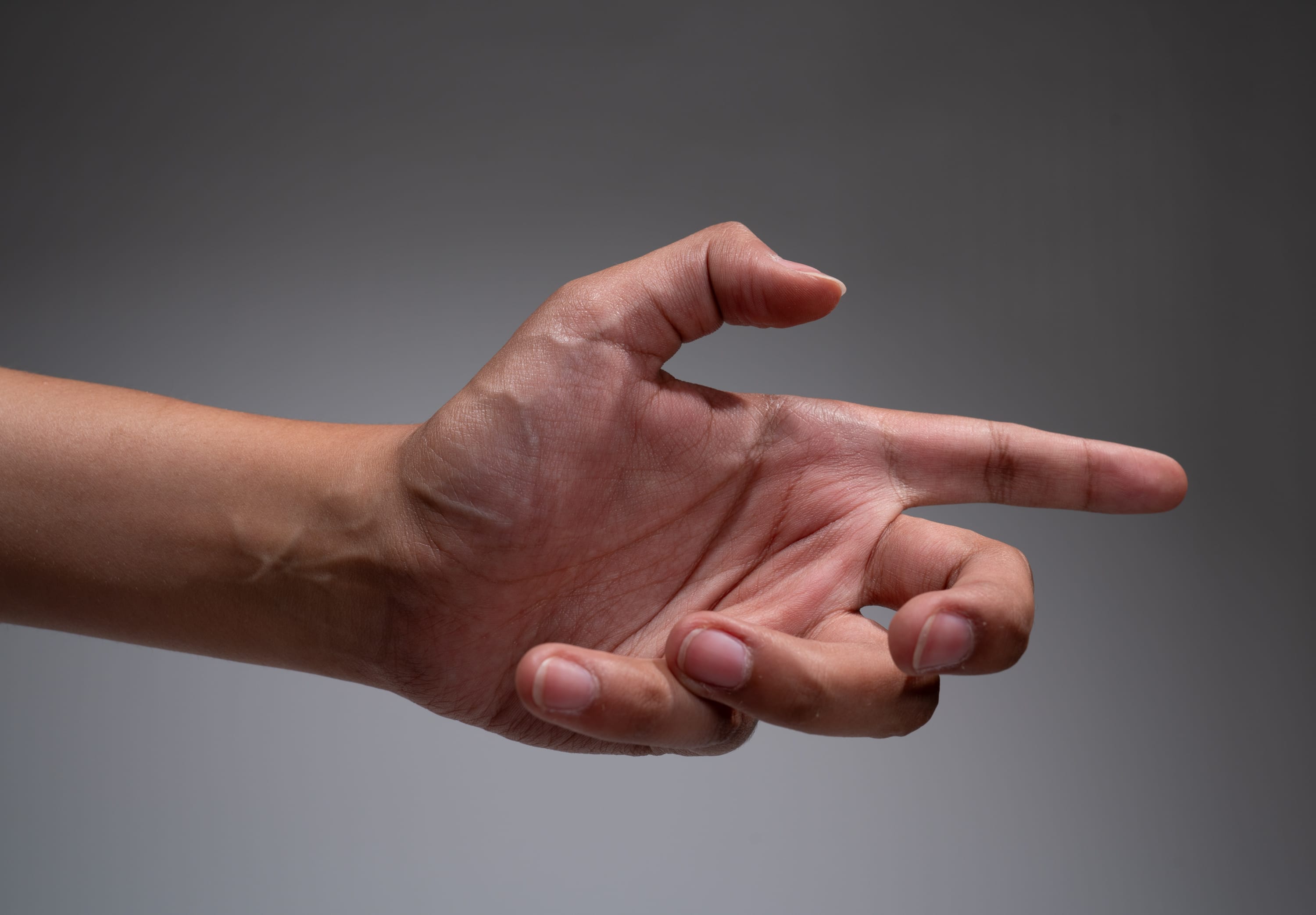 a hand with its fingers curled up except for the index finger which is pointing out.