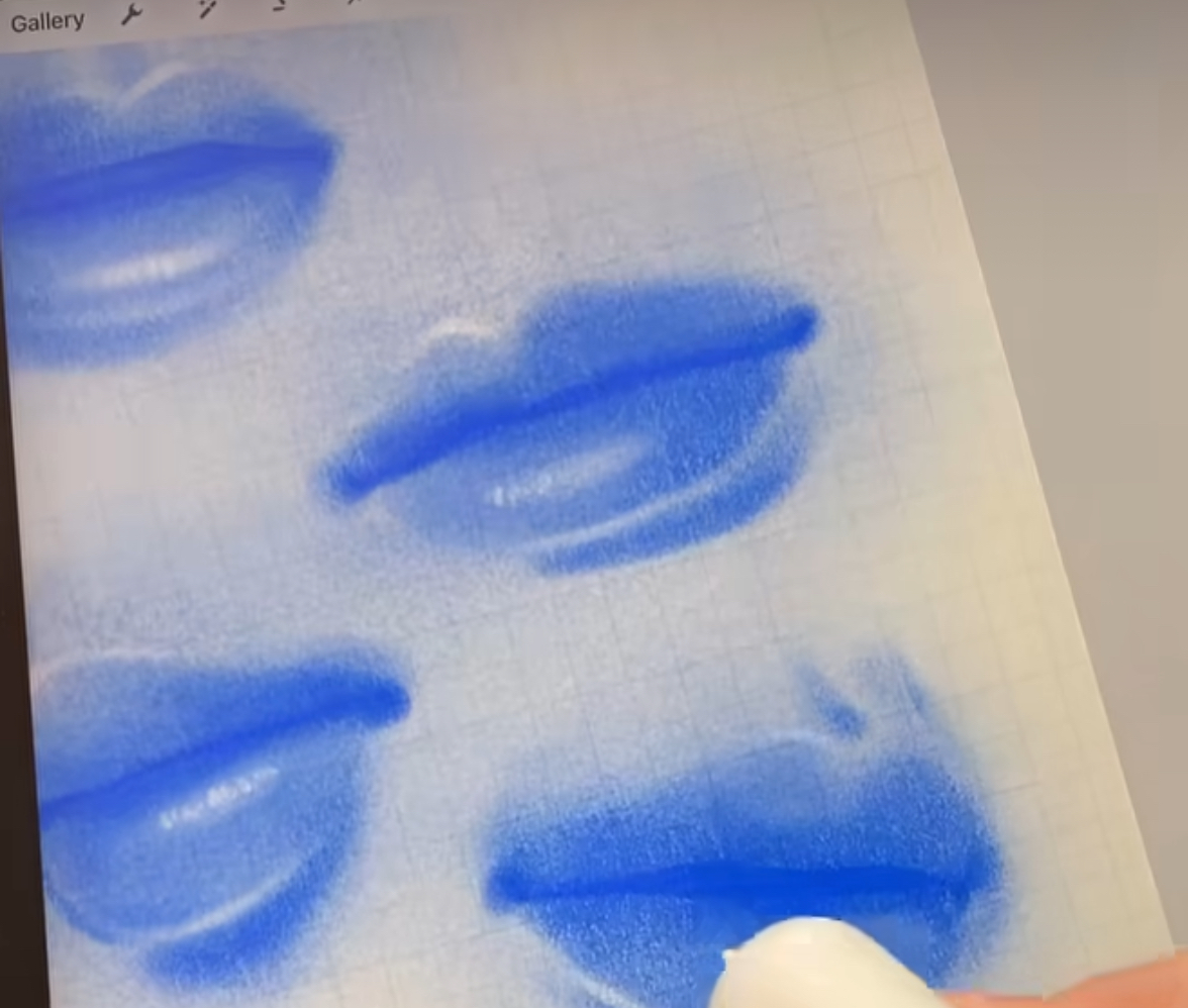 a sketch of four blue lips on a white paper with grid lines on a digital drawing pad. the bottom right lip is being blended with a white digital brush.