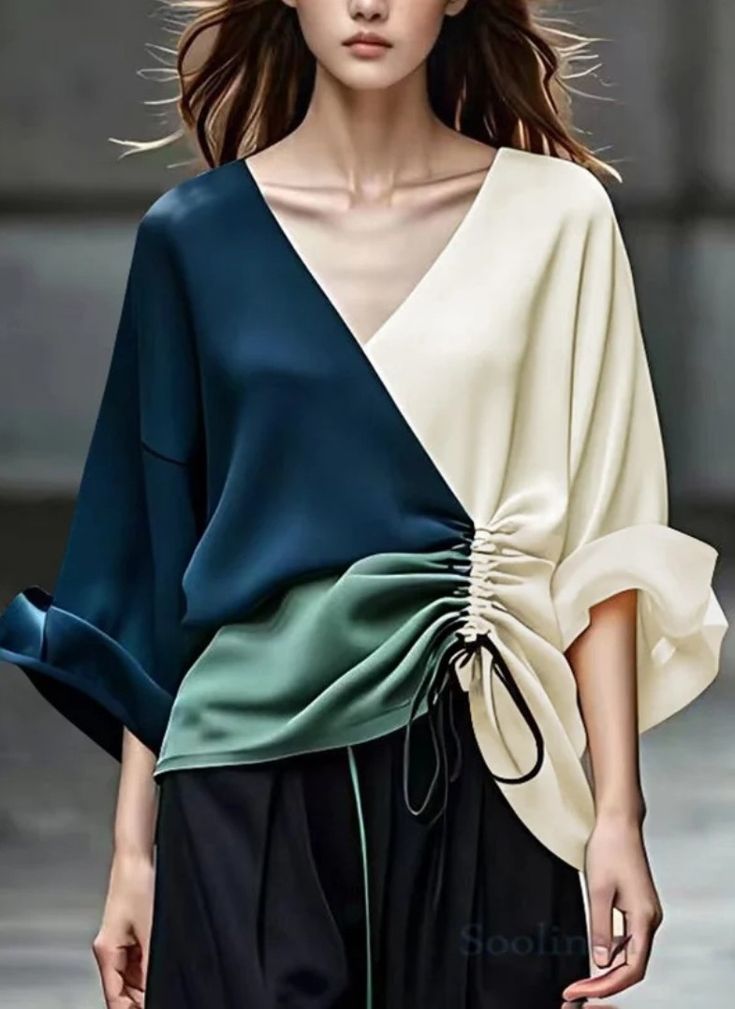 a woman wearing a stylish silk top in shades of blue, green, and white, featuring a vneckline, drawstring detail, and ruffle sleeves. the model is posing in a studio setting.