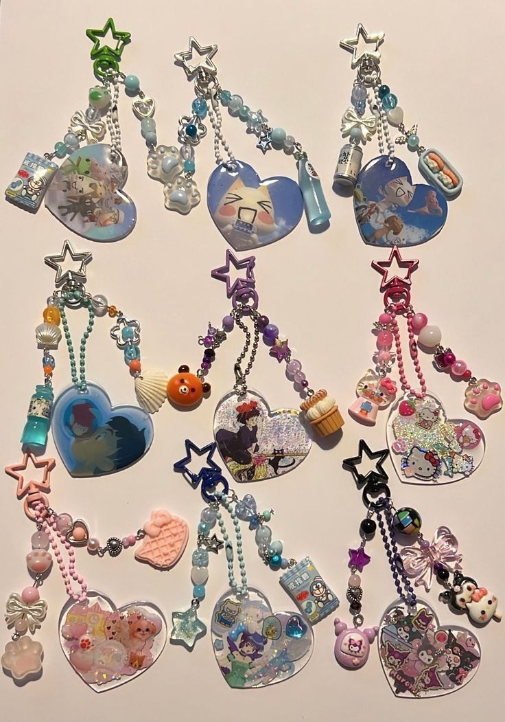 the image shows a collection of nine heartshaped keychains, each featuring different anime or cartoon characters and embellished with stars, beads, and miniature figures. the keychains have a handmade, kawaii aesthetic and are arranged on a light surface. they showcase various popular characters, including sanrio's hello kitty, my melody, kuromi, pompompurin, and cinnamoroll, along with other anime and cartoon figures. the keychains incorporate pastel colors, ribbons, bows, and resin art, contributing to their cute and playful appearance.