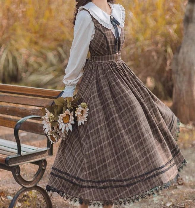 a young woman wearing a brown plaid vintage dress with a white blouse stands next to a park bench. she holds a bouquet of sunflowers while looking down. the photo is taken outdoors with natural lighting, showcasing the woman's romantic and cottagecoreinspired outfit.