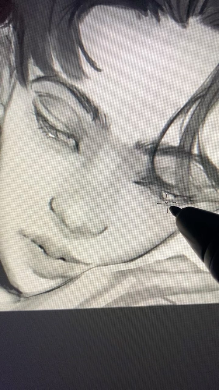 the image shows a closeup of a digital drawing in progress on a graphic tablet.  the artist is using a stylus to add details to a grayscale portrait of a young man's face, likely inspired by anime or manga style. the drawing is largely complete, but the artist is adding final shading and detail to the eye area.  the image shows the drawing itself and a portion of the artist’s stylus.