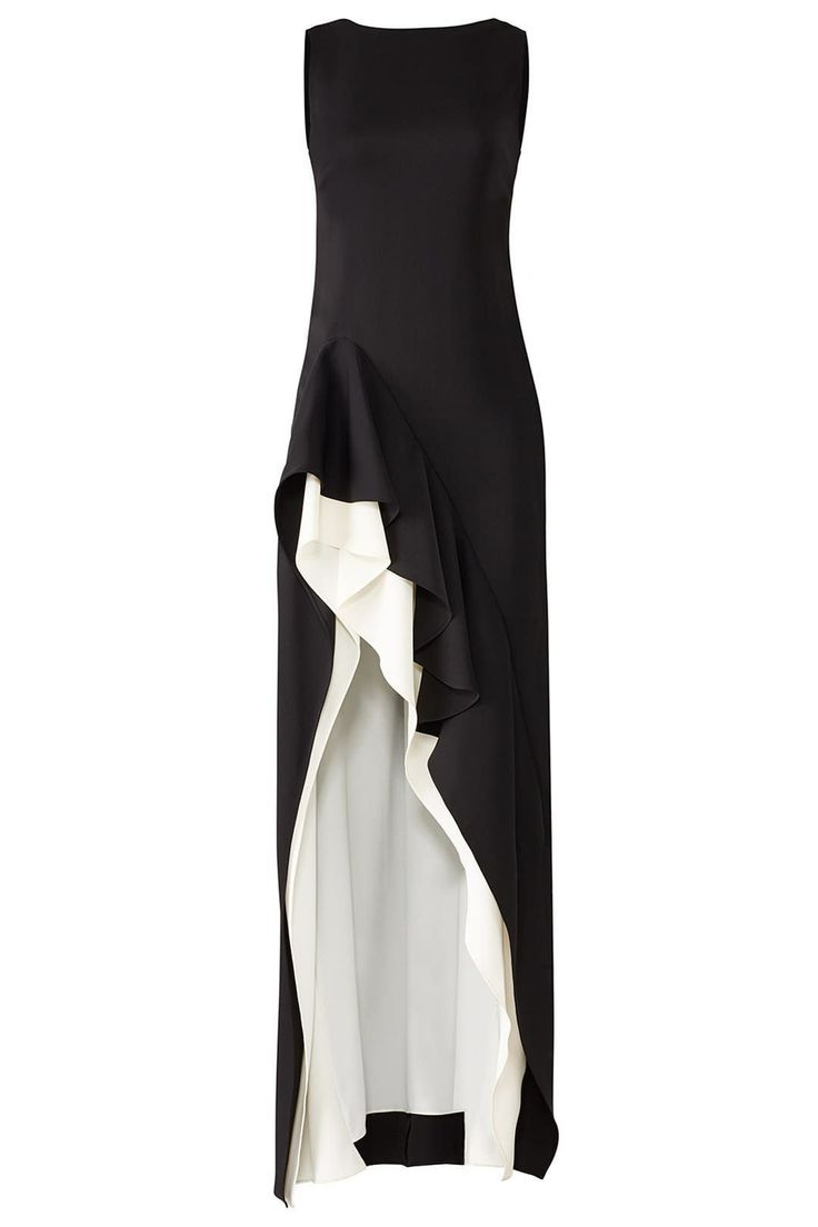 a sleeveless, floorlength gown is displayed on a white background. the dress is predominantly black, but features a white ruffle detail cascading from the left hip down to the hem. the hem is highlow, creating an asymmetrical silhouette. the dress has a simple, round neckline.