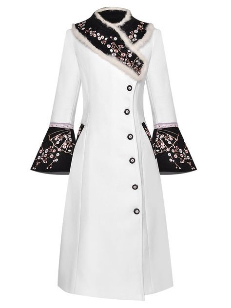 a white long coat with black embroidery and a fur collar. the coat has long sleeves and is fastened with buttons.