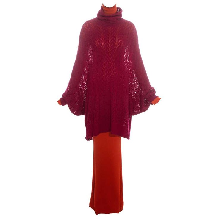 this is a photo of a woman's maroon sweater dress. the sweater is a longsleeved knit turtleneck sweater with a loose fit, and the dress is a long, flowing skirt with a high waistline.  the sweater is in a dark maroon color, and the skirt is a lighter shade of red.
