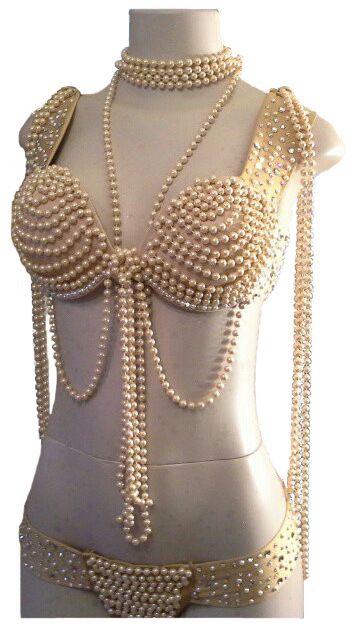 a mannequin is wearing a pearl bra and thong. the bra is covered in pearls, as is the thong. a pearl choker and necklace are also worn by the mannequin.