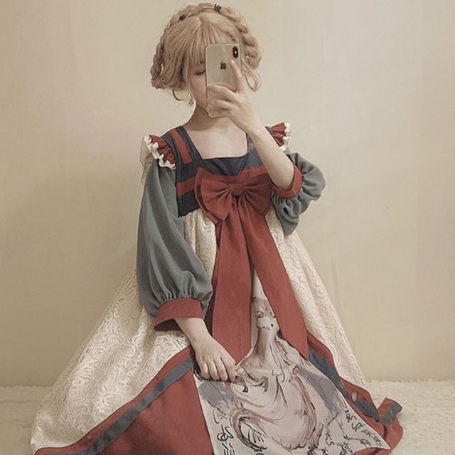 a young woman is standing indoors, taking a mirror selfie while wearing an elaborate lolita fashion dress. the dress is primarily creamcolored with a large, flowing skirt. it features a red bodice with a large bow at the waist and contrasting gray sleeves. the skirt features a printed design reminiscent of classical art. her blonde hair is styled in a halfupdo with braids. the overall aesthetic is romantic and whimsical.