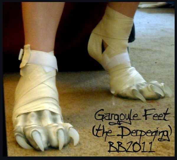 a photo of someone wearing a gargoyle feet costume. their feet and lower legs are completely covered in white bandages with white claws attached to the toes. the costume is very realistic and looks quite creepy. the image is taken from a slightly low angle and the background is blurry.