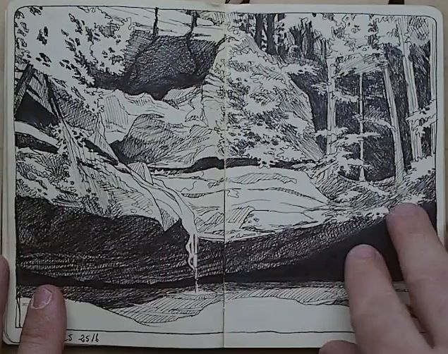 a black and white pen and ink sketch in a notebook. the drawing depicts a landscape with trees and rocks, possibly a forest scene. a hand is visible on the right side of the image, presumably holding the notebook open. the date "25/16" is written in the lower left corner.