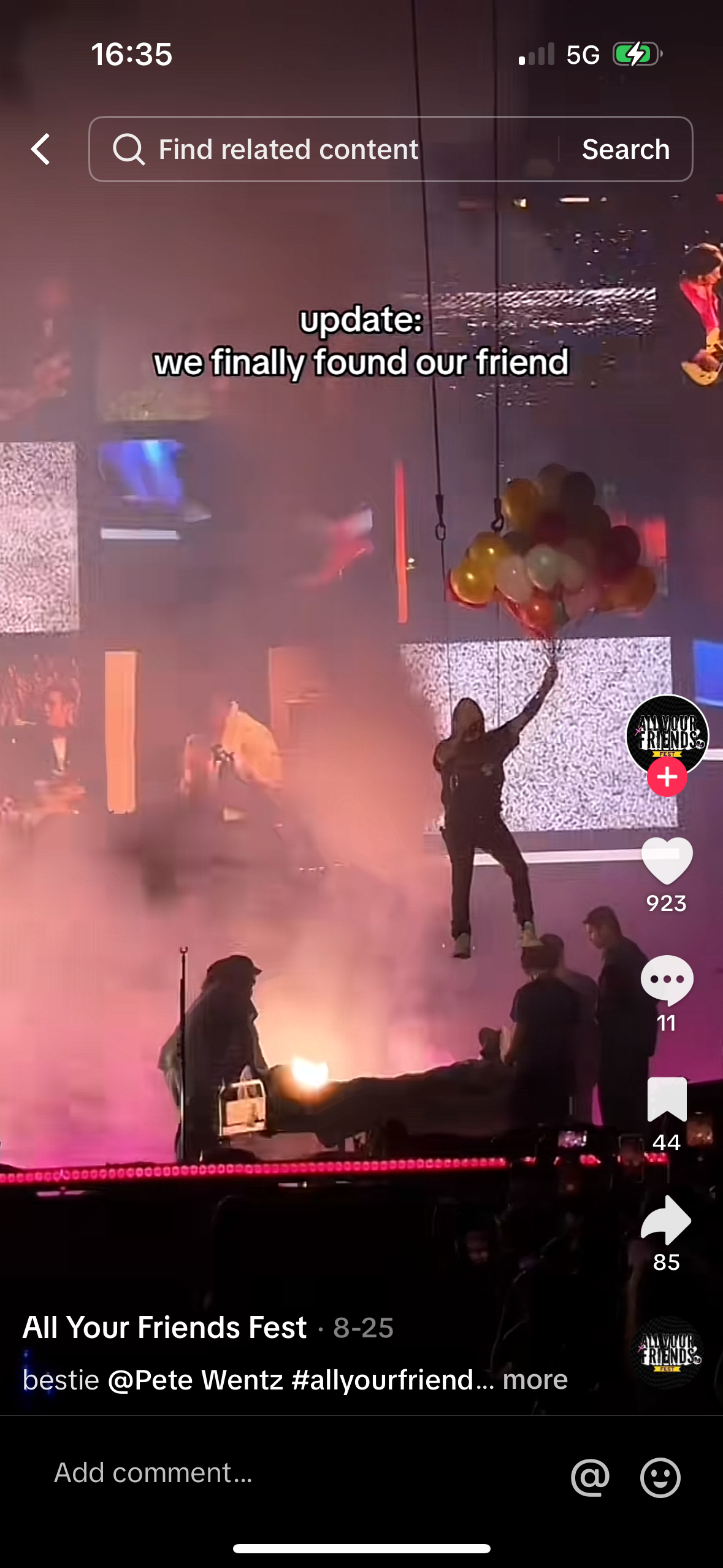 this is a photo taken at a concert featuring fall out boy. the stage is bathed in lights and the crowd is cheering and waving their hands. the band is playing a song and having a great time. pete wentz is on stage with a microphone and is singing.