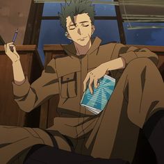 a young man with short green hair is sitting on the floor of a room. he is wearing a brown jumpsuit and has a book in his lap. he is holding a pen in his right hand and looking off to the left. the room is dark and there is a window in the background. the lighting is soft and the overall tone of the image is calm and contemplative.