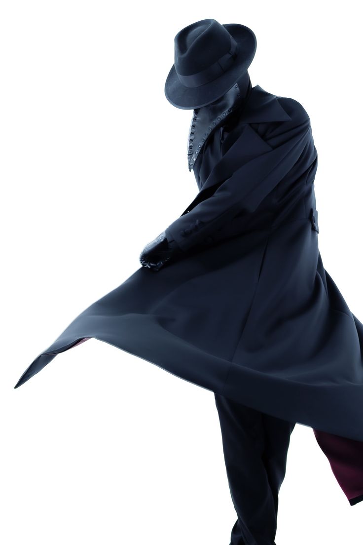 a man wearing a black coat and a fedora hat stands with his back to the camera. the image is a silhouette, with the man's features obscured by the darkness. the coat is long and flowing, and the hat is tilted at a rakish angle. the background is white. the image evokes a sense of mystery and intrigue.