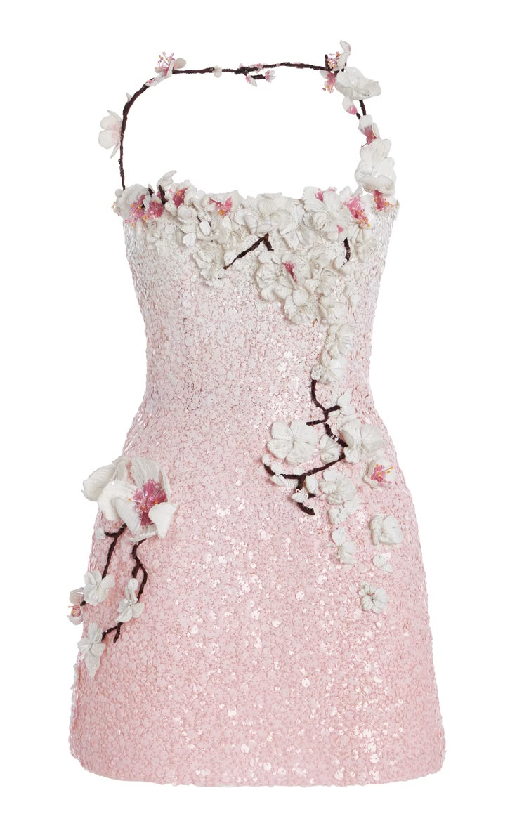 a light pink cocktail dress adorned with white and pink cherry blossoms. the dress is sleeveless, short, and covered in sequins. the blossoms appear as embellishments, scattered artfully across the dress, with some also forming a garlandlike neckline.