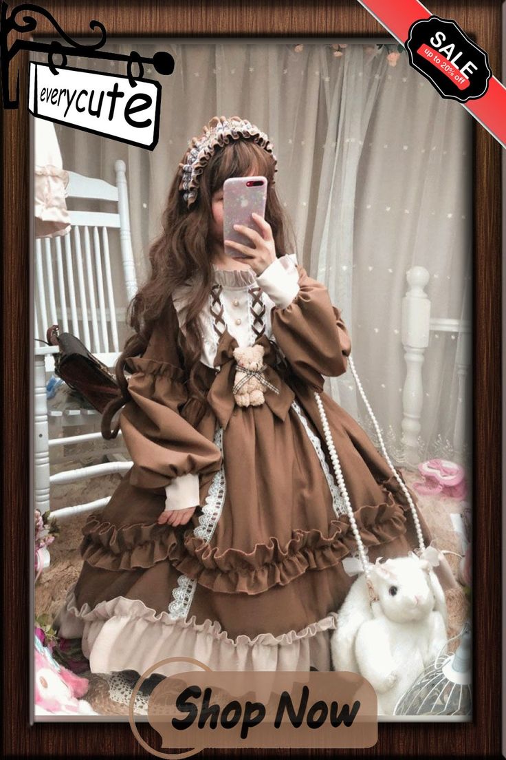 a girl wearing a brown and cream lolita fashion dress is posing with a matching purse. she is indoors and holding a phone up that is partially obscuring her face.
