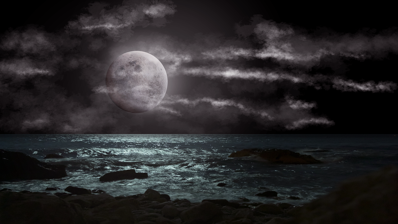 a nighttime seascape under a full moon. the ocean waves reflect the moonlight, and the sky is filled with dark, ominous clouds. large rocks are scattered along the shore, adding to the dramatic scene. the overall mood is dark and mysterious.