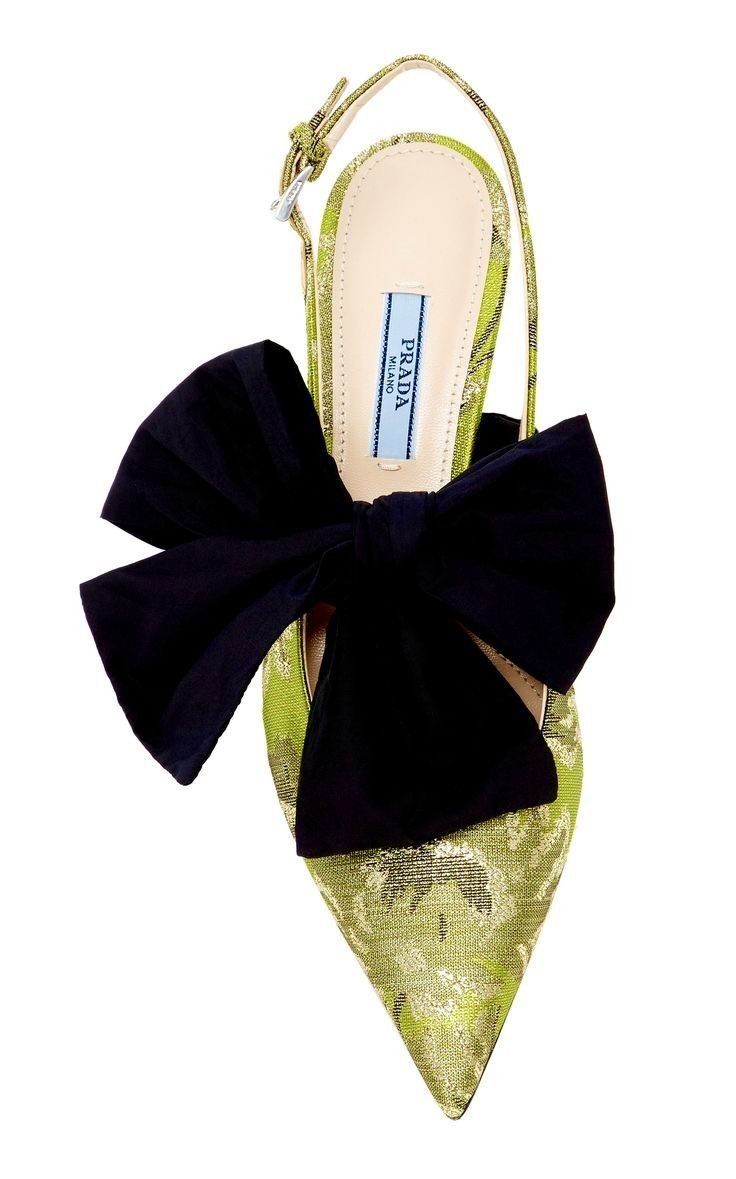 a single prada slingback pointedtoe pump is shown on a white background. the pump is chartreuse with a black bow.